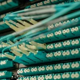 Detailed view of fiber optic cables connected to a server rack, showcasing modern technology.
