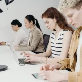 Diverse group of professionals working on laptops at a bright office workstation.