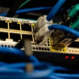 Close-up image of ethernet cables plugged into a network switch, showcasing IT infrastructure.
