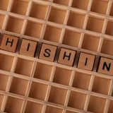 High-angle view of wooden letter tiles spelling 'Phishing', representing online security threats.